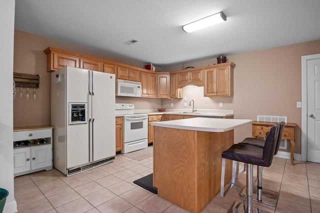 kitchen featuring white appliances, light countertops, light tile patterned flooring, and a sink