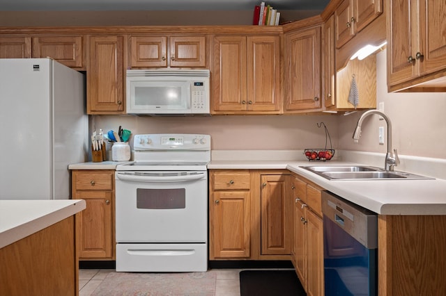 kitchen with white appliances, a sink, light tile patterned flooring, and light countertops