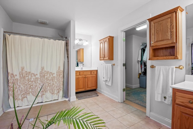 full bath with vanity, tile patterned floors, curtained shower, and a walk in closet