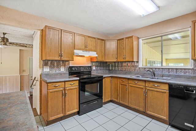 3502 Oak Ridge Dr, Chattanooga, TN 37415 - kitchen featuring black appliances, under cabinet range hood, a textured ceiling, decorative backsplash, and wainscoting