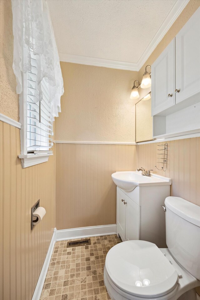 3502 Oak Ridge Dr, Chattanooga, TN 37415 - bathroom featuring vanity, wainscoting, a textured ceiling, and ornamental molding