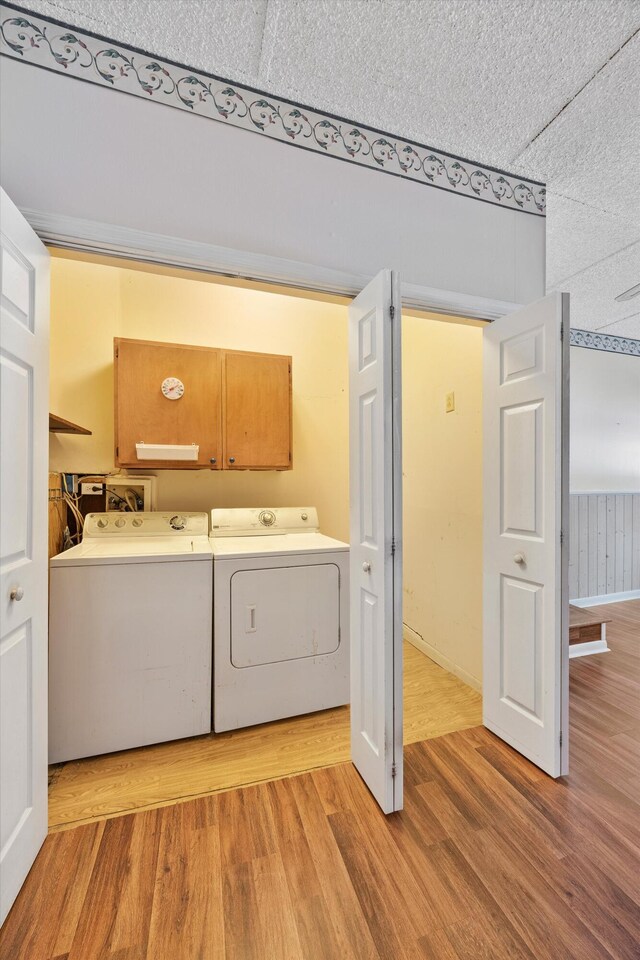 3502 Oak Ridge Dr, Chattanooga, TN 37415 - washroom with cabinet space, washing machine and dryer, and light wood-type flooring