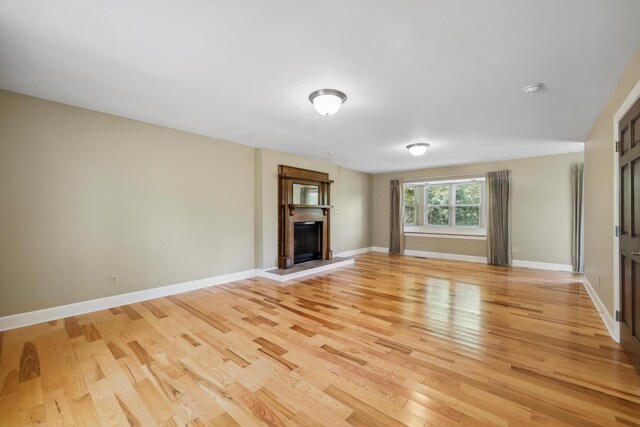 7470 Twin Brook Dr, Chattanooga, TN 37421 - unfurnished living room with light wood-style floors, a fireplace with raised hearth, and baseboards