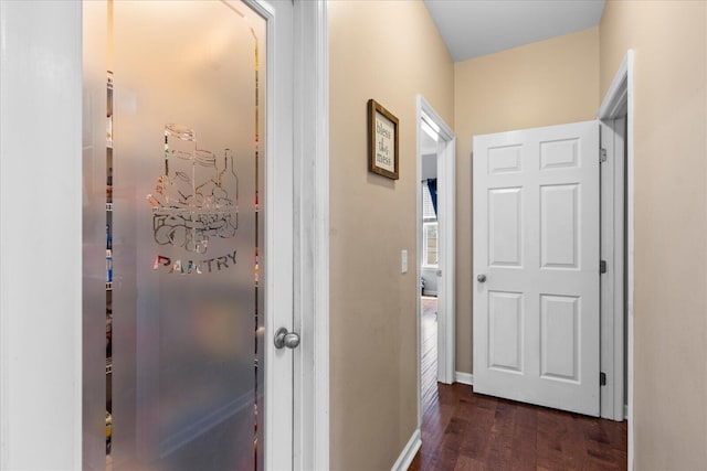 hallway with dark wood finished floors and baseboards
