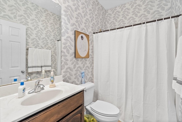 full bathroom featuring wallpapered walls, toilet, and vanity