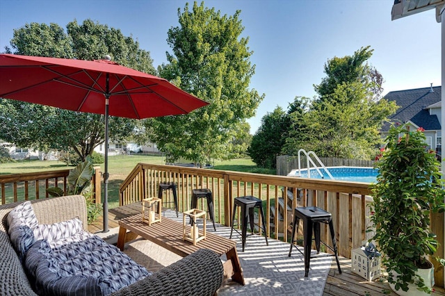 wooden terrace featuring an outdoor pool and a yard