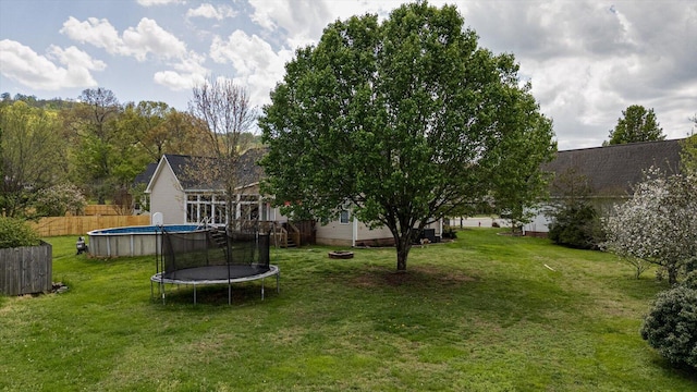 view of yard with a trampoline and a wooden deck