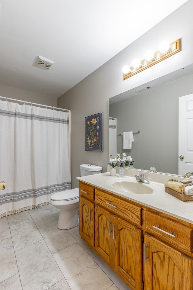 full bathroom featuring toilet, vanity, and marble finish flooring