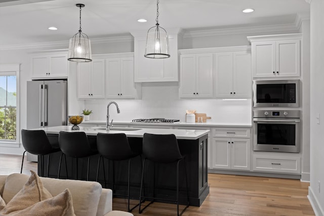 kitchen featuring stainless steel appliances, a sink, light countertops, a breakfast bar, and backsplash