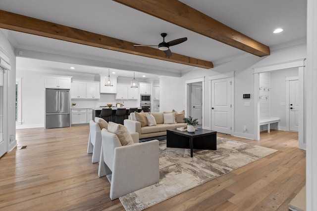 living room featuring beamed ceiling, a ceiling fan, recessed lighting, light wood finished floors, and baseboards