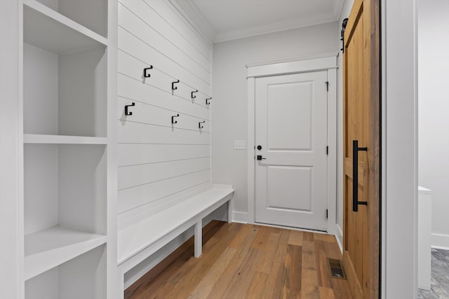 mudroom with light wood-style floors and ornamental molding