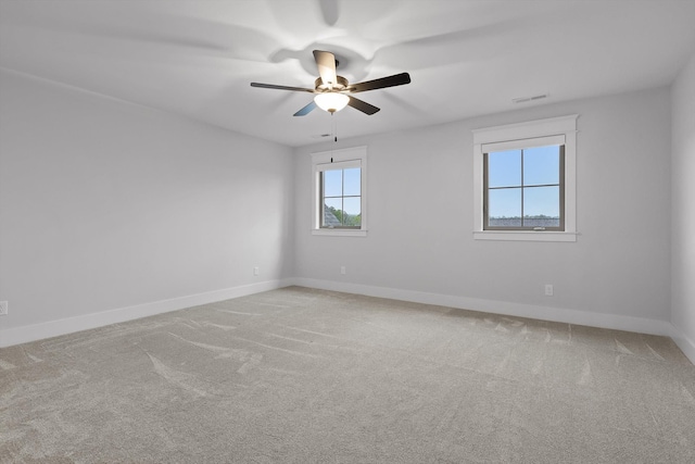 spare room with baseboards, light carpet, and ceiling fan