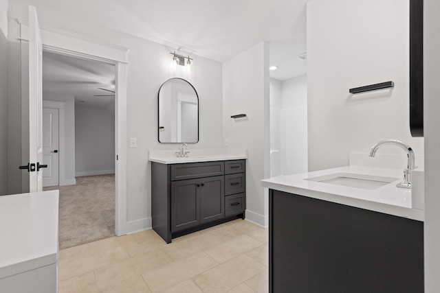 bathroom featuring vanity, baseboards, tile patterned flooring, and a shower
