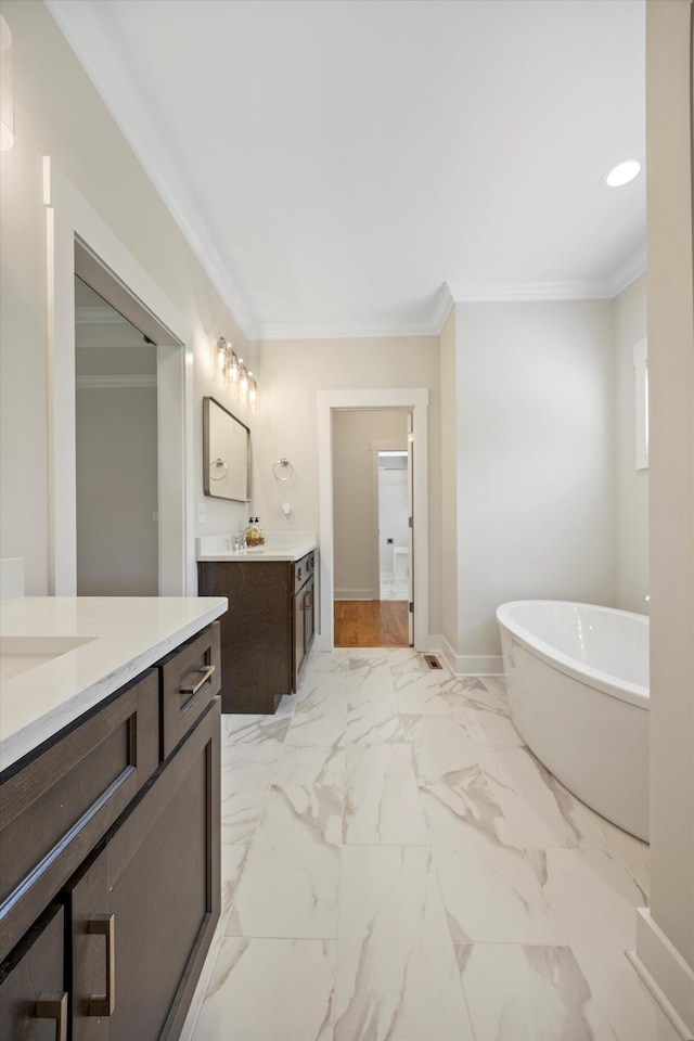 2664 Mowbray Pike Unit 2, Soddy Daisy, TN 37379 - bathroom with two vanities, a freestanding tub, ornamental molding, marble look tiles, and baseboards