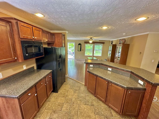 2218 Harvest Ln, Dandridge, TN 37725 - kitchen with black appliances, ornamental molding, dark countertops, brown cabinets, and a kitchen island