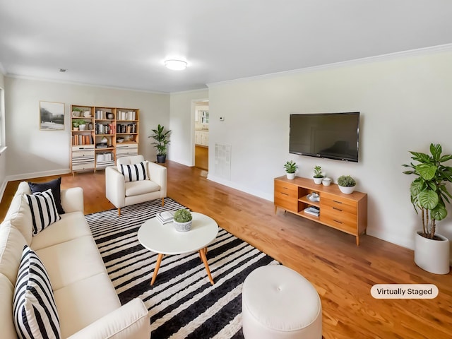 living area featuring ornamental molding, wood finished floors, and baseboards