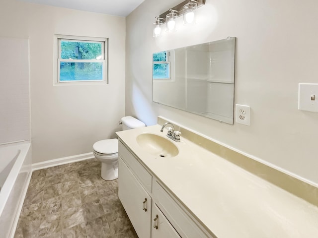 bathroom featuring toilet, vanity, and baseboards