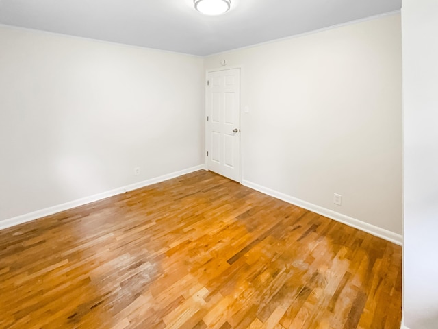 empty room with light wood finished floors and baseboards