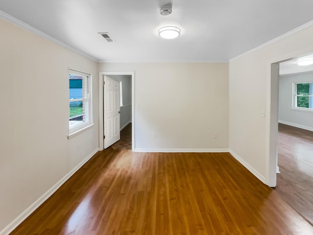 spare room featuring ornamental molding, wood finished floors, baseboards, and a smoke detector