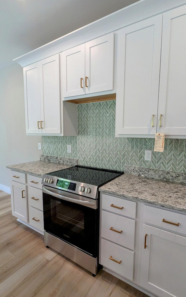 9162 Fuller Rd, Chattanooga, TN 37421 - kitchen featuring electric stove, light wood-style floors, white cabinetry, and tasteful backsplash