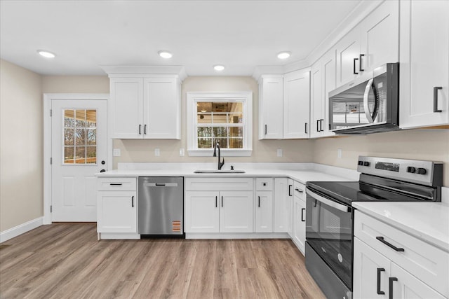 118 Earls Way, Chatsworth, GA 30705 - kitchen featuring appliances with stainless steel finishes, a sink, light wood-style flooring, healthy amount of natural light, and recessed lighting