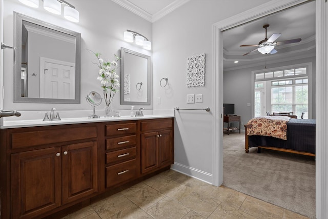 ensuite bathroom featuring ornamental molding, a ceiling fan, baseboards, and double vanity