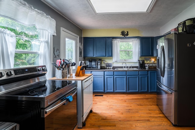976 Chamberlain Rd, Lafayette, GA 30728 - kitchen featuring appliances with stainless steel finishes, a sink, blue cabinets, and light wood-type flooring