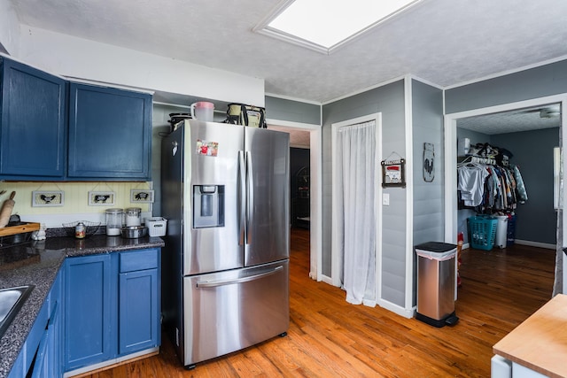 976 Chamberlain Rd, Lafayette, GA 30728 - kitchen with stainless steel fridge with ice dispenser, blue cabinets, light wood-style floors, and dark countertops