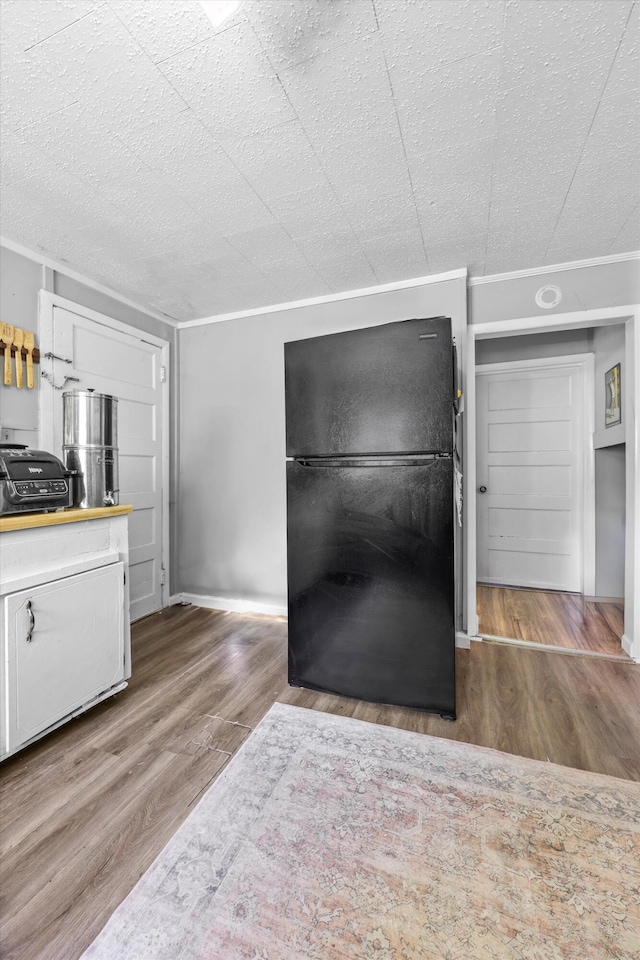 506 Daugherty St, Lafayette, GA 30728 - kitchen with freestanding refrigerator, white cabinetry, crown molding, wood finished floors, and light countertops
