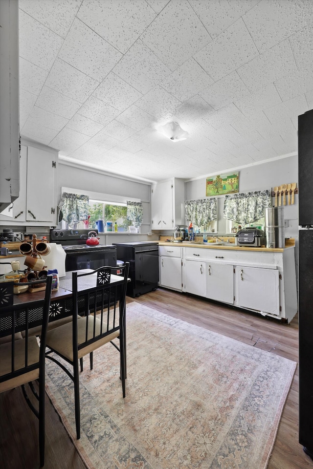 506 Daugherty St, Lafayette, GA 30728 - kitchen featuring white cabinets, light wood finished floors, light countertops, and black dishwasher