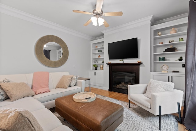 715 Forest Ave, Chattanooga, TN 37405 - living room with crown molding, light wood-style floors, a glass covered fireplace, ceiling fan, and built in features