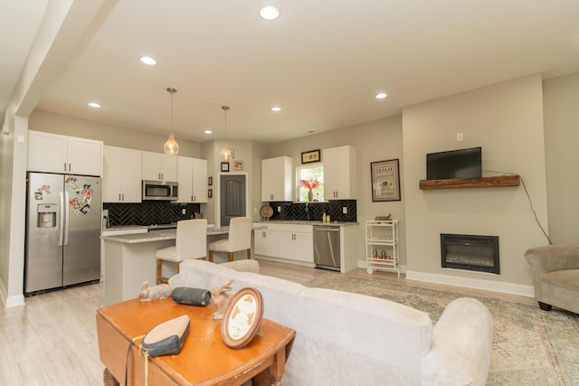 714 W 42nd St, Chattanooga, TN 37410 - living room featuring recessed lighting, light wood-style flooring, baseboards, and a glass covered fireplace