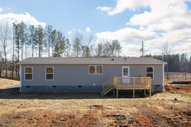rear view of property featuring crawl space, a deck, and a shingled roof