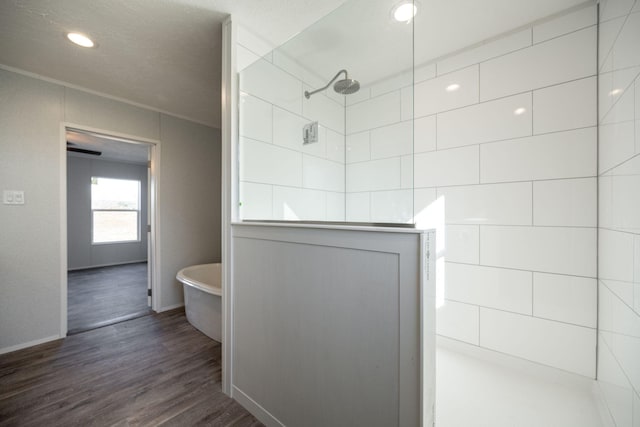 bathroom featuring a freestanding tub, a walk in shower, wood finished floors, baseboards, and recessed lighting