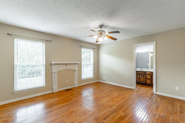 13709 Stormer Rd, Soddy Daisy, TN 37379 - unfurnished living room featuring a ceiling fan, light wood finished floors, a textured ceiling, and baseboards
