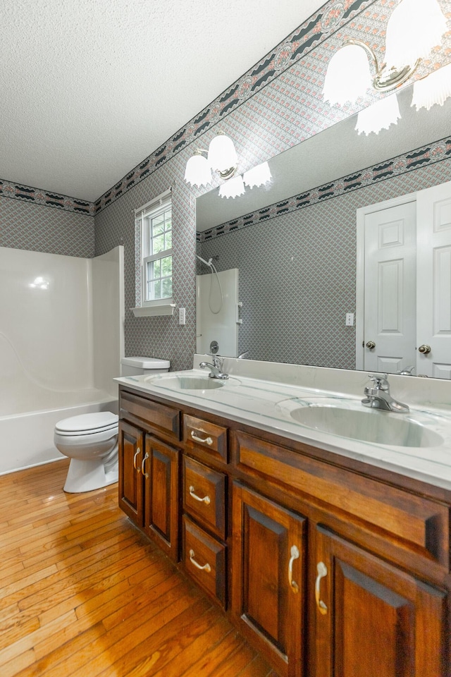 13709 Stormer Rd, Soddy Daisy, TN 37379 - full bath with hardwood / wood-style floors, toilet, washtub / shower combination, double vanity, and a textured ceiling