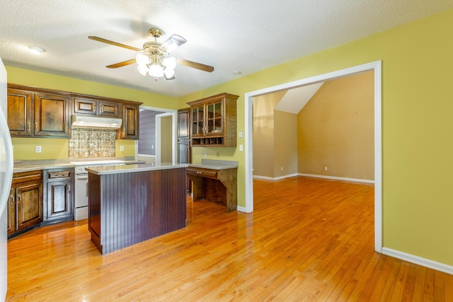 13709 Stormer Rd, Soddy Daisy, TN 37379 - kitchen with under cabinet range hood, a kitchen island, light countertops, a ceiling fan, and light wood finished floors