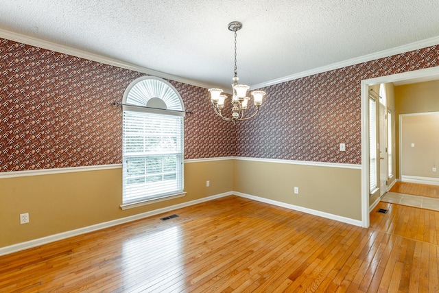 13709 Stormer Rd, Soddy Daisy, TN 37379 - unfurnished room with wallpapered walls, a chandelier, hardwood / wood-style floors, plenty of natural light, and a textured ceiling