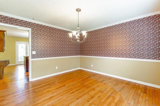13709 Stormer Rd, Soddy Daisy, TN 37379 - spare room with wallpapered walls, light wood-type flooring, a chandelier, baseboards, and crown molding
