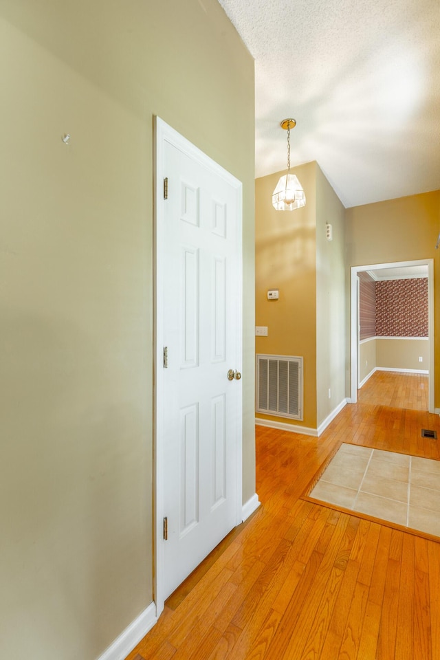 13709 Stormer Rd, Soddy Daisy, TN 37379 - unfurnished room featuring light wood-style floors, baseboards, a chandelier, and vaulted ceiling