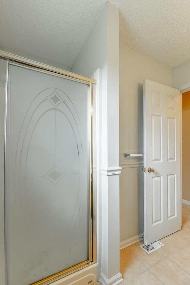 13709 Stormer Rd, Soddy Daisy, TN 37379 - bathroom with tile patterned flooring, a stall shower, a textured ceiling, and baseboards