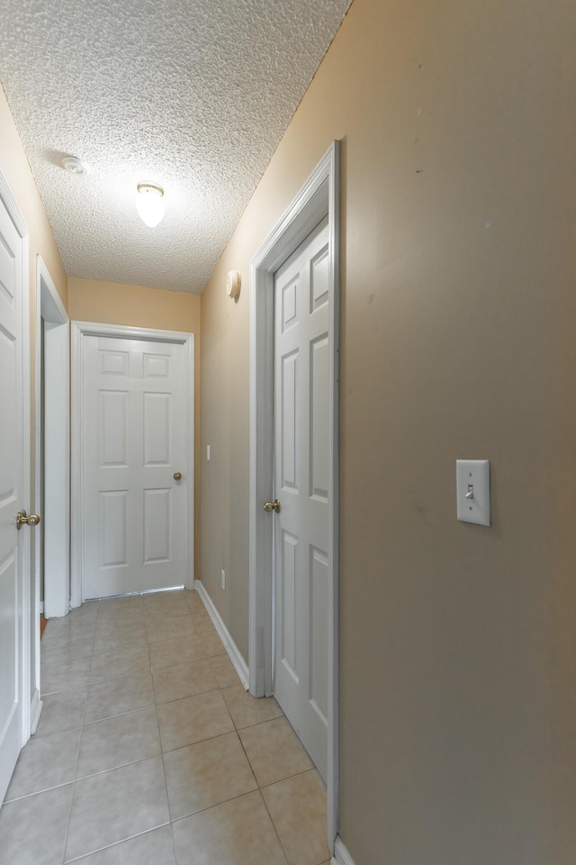 13709 Stormer Rd, Soddy Daisy, TN 37379 - corridor featuring light tile patterned floors, a textured ceiling, and baseboards