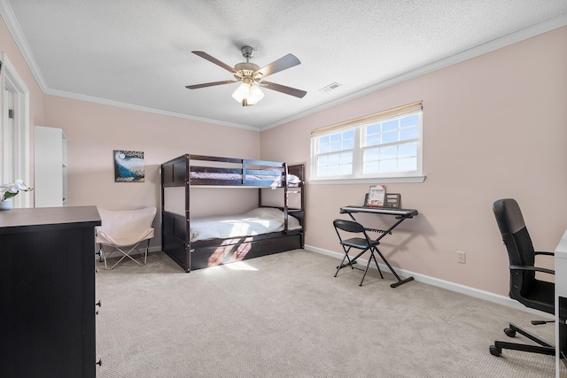 carpeted bedroom with crown molding, baseboards, a desk, a textured ceiling, and a ceiling fan