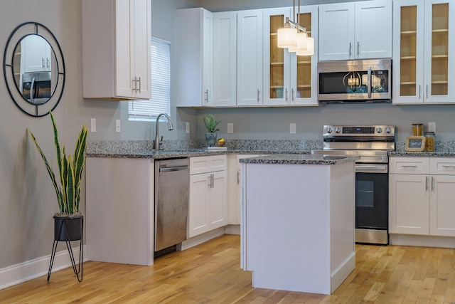 11 Woodvale Ave, Chattanooga, TN 37411 - kitchen with stainless steel appliances, light wood-type flooring, a sink, a kitchen island, and white cabinetry