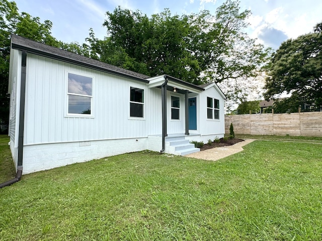 rear view of house with crawl space, entry steps, and a shingled roof