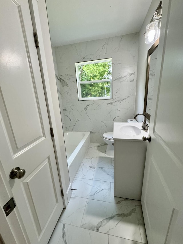 bathroom featuring marble finish floors, vanity, a tub, and toilet