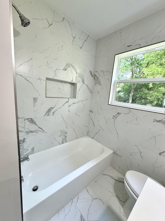 bathroom featuring toilet, marble finish floors, and shower / bath combination