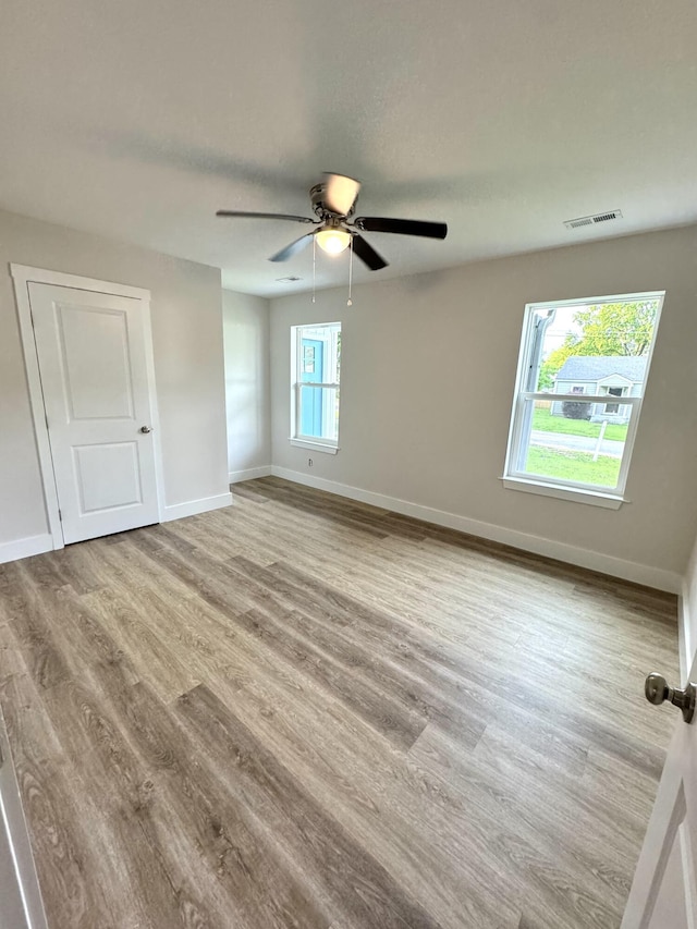 spare room featuring wood finished floors, baseboards, and a ceiling fan