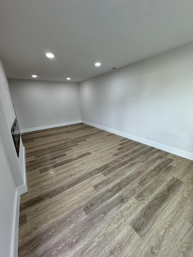 spare room featuring wood finished floors, recessed lighting, and baseboards