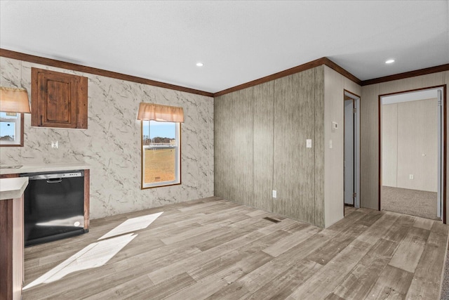 unfurnished living room featuring ornamental molding, light wood-style flooring, and healthy amount of natural light